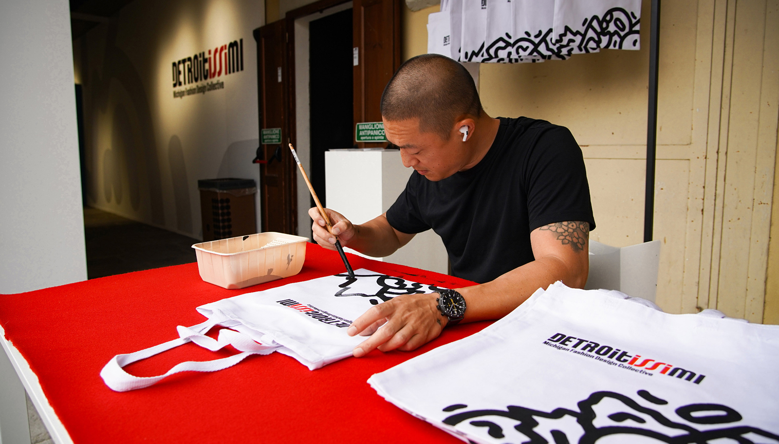 Photo of Mike Han painting tote bags